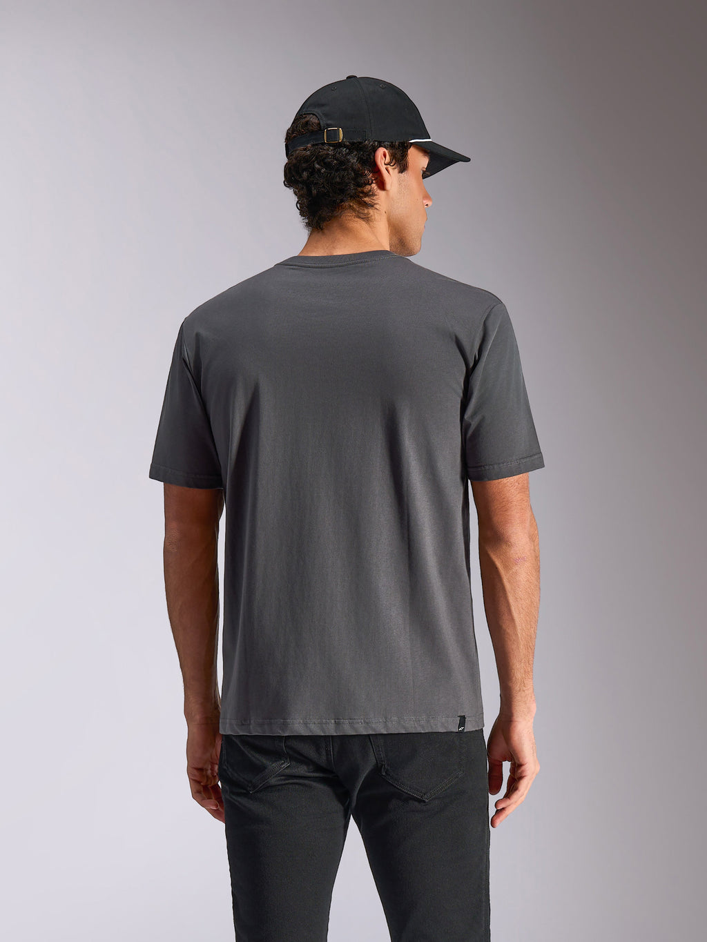 Camiseta Alpinestars Ellipsoid CSF, camiseta de manga corta, gris carbón, vista posterior en el modelo, ropa urbana informal con una pequeña etiqueta del logo en el dobladillo