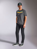 Camiseta Alpinestars Ellipsoid CSF, camiseta de manga corta, gris carbón, con la palabra astars curvada en degradado de color y logo blanco, usada por un modelo con pantalones negros y gorra, estilo casual motorsport streetwear