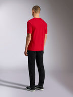Alpinestars Plate CSF Tee, camiseta de manga corta, roja, vista posterior, usada con pantalones negros y zapatillas, ropa de calle casual inspirada en el automovilismo