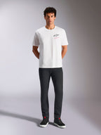 Alpinestars Pop Helmet CSF Tee, Short Sleeve T-Shirt, White, worn by a model with black pants and black high-top sneakers, front Astars logo with pink 'Alpinestars Protects' text, casual motorsport streetwear