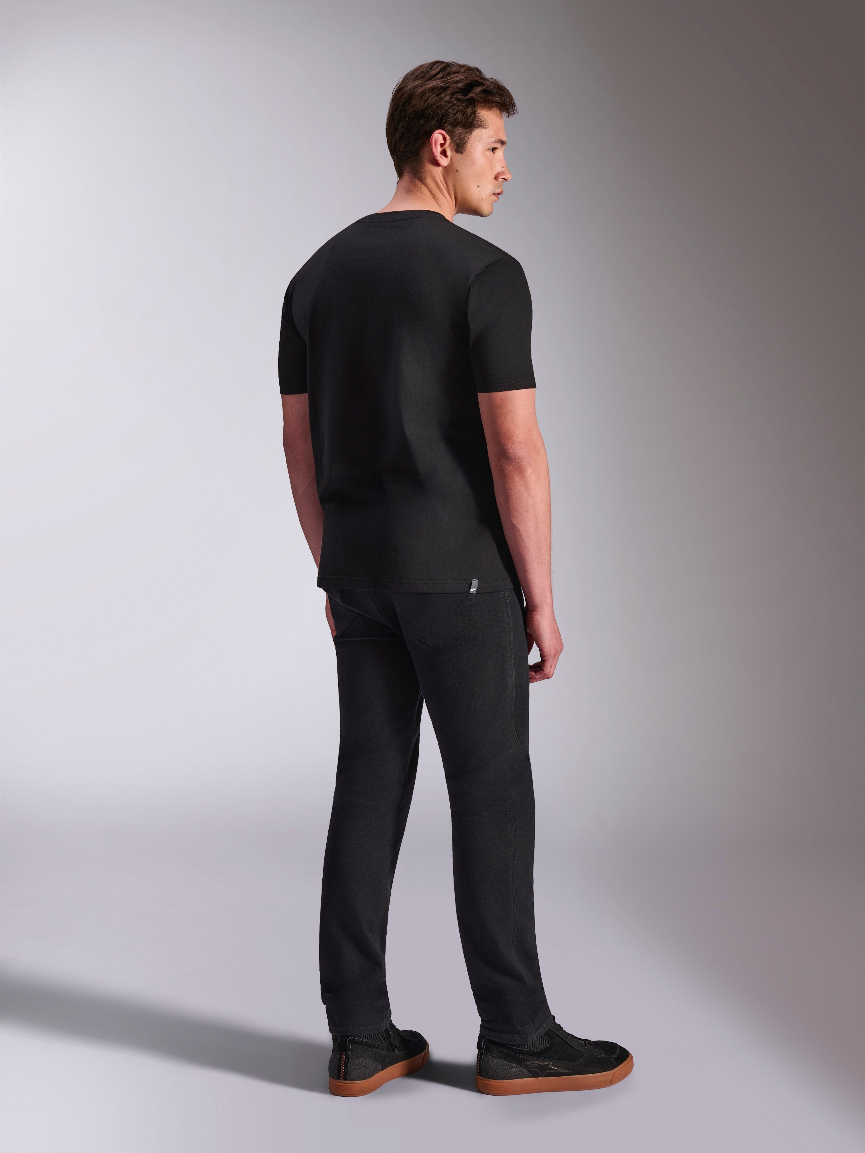 Alpinestars Abus CSF Tee, Short Sleeve T-Shirt, Black, back view on male model, casual motorsport streetwear, paired with dark pants and sneakers