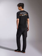Alpinestars Lanes CSF Tee, camiseta de manga corta negra, vista posterior con el logotipo de Alpinestars en blanco y gráficos de rayas rojas, naranjas y amarillas, ropa urbana casual de automovilismo combinada con pantalones cargo negros