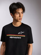 Alpinestars Lanes CSF Tee, camiseta de manga corta, negra, con logotipos blancos de Astars y Alpinestars y rayas rojas y amarillas, ropa casual de estilo streetwear motorsport usada por un modelo