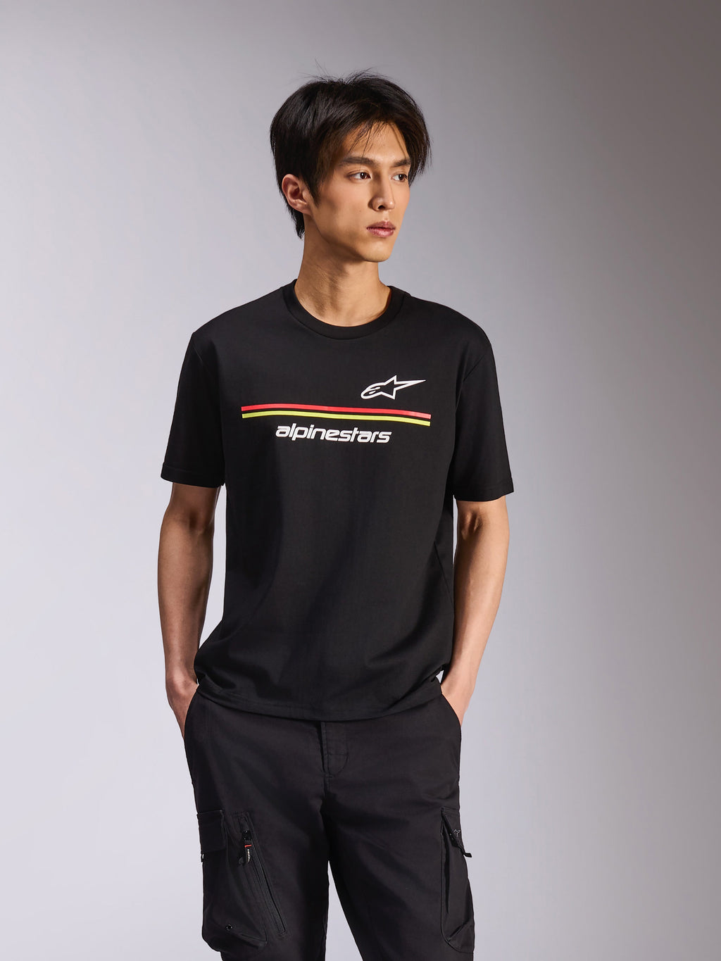 Alpinestars Lanes CSF Tee, camiseta de manga corta, negra, logotipos de Astars y Alpinestars en blanco con rayas horizontales rojas y amarillas, ropa urbana casual de automovilismo