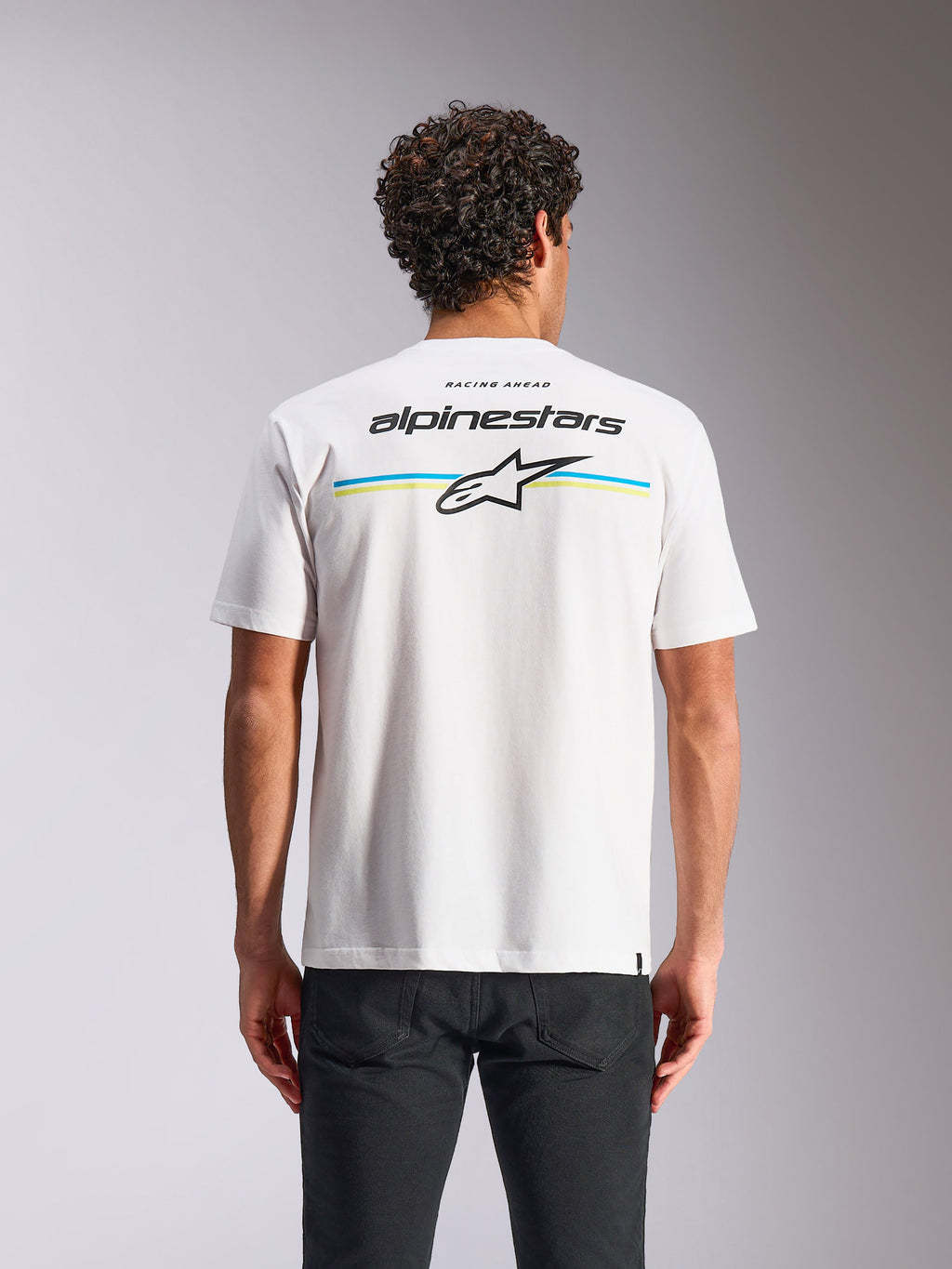 Camiseta Alpinestars Lanes CSF, de manga corta, blanca, vista posterior con rayas multicolores y logotipos de Alpinestars y Astars, ropa urbana casual de automovilismo