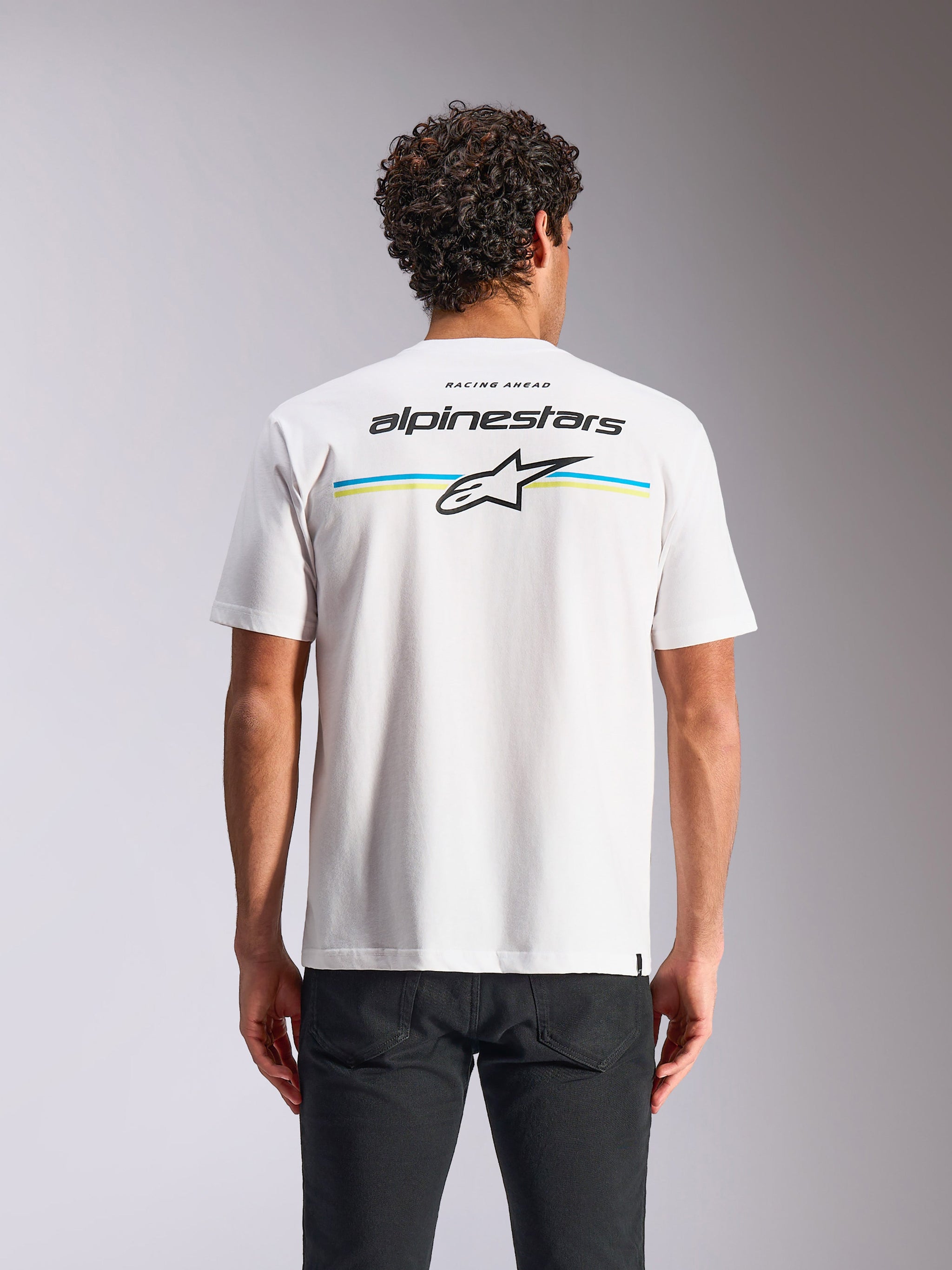 Camiseta Alpinestars Lanes CSF, de manga corta, blanca, vista posterior con rayas multicolores y logotipos de Alpinestars y Astars, ropa urbana casual de automovilismo