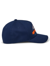 Gorra Alpinestars Instinct, azul marino, visera curva con corona estructurada, vista de perfil lateral con logotipo impreso en degradado naranja y azul, ropa deportiva casual
