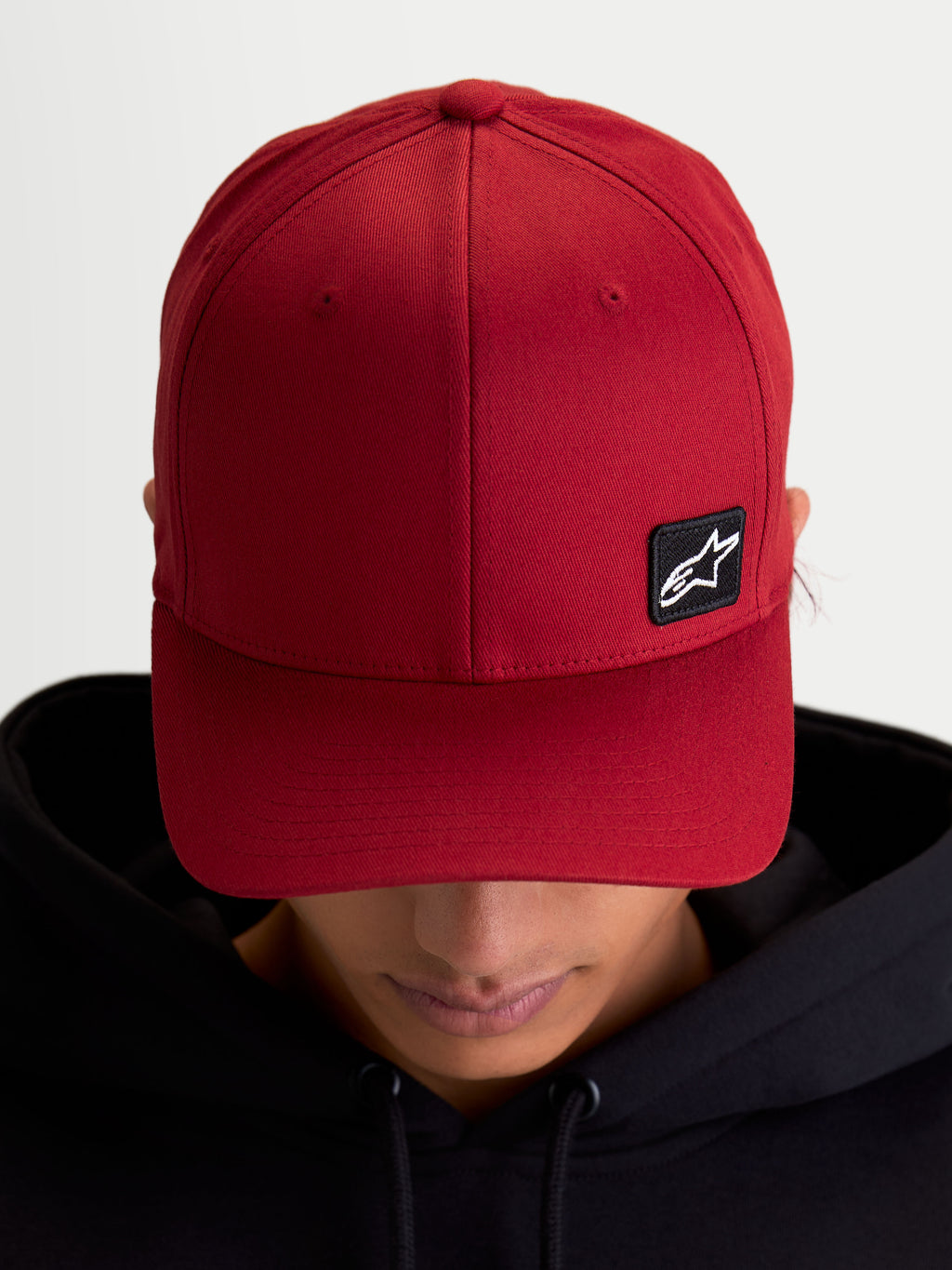 Alpinestars gorra Pivot, gorra de béisbol deportiva de estilo casual, unisex, roja, con visera curva, corona estructurada y pequeño parche con logotipo Astars negro bordado en tejido de sarga, vista en modelo