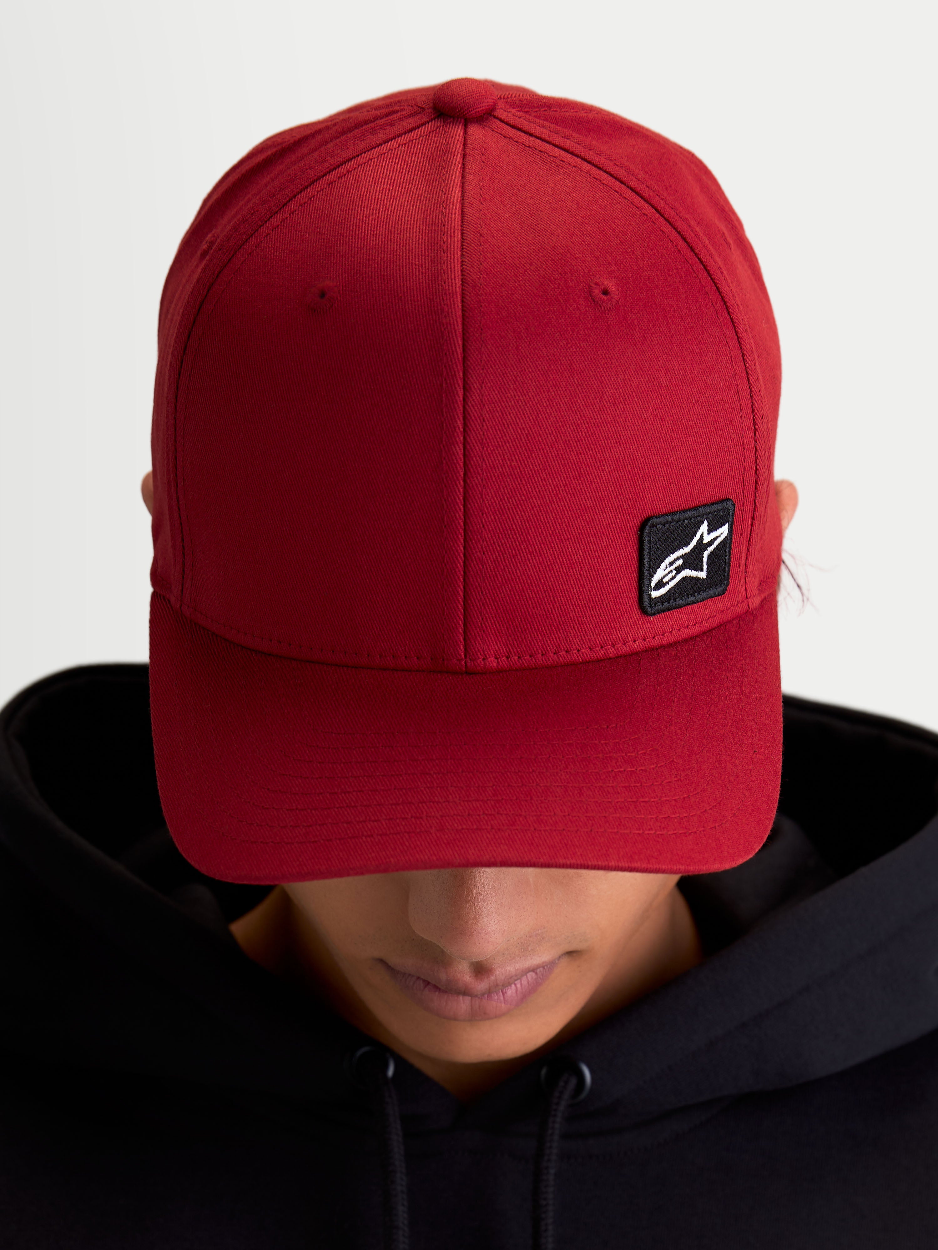 Alpinestars gorra Pivot, gorra de béisbol deportiva de estilo casual, unisex, roja, con visera curva, corona estructurada y pequeño parche con logotipo Astars negro bordado en tejido de sarga, vista en modelo