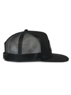 Gorra Alpinestars Contender Trucker, gorra trucker negra, vista de perfil lateral, con visera plana y paneles traseros de malla transpirable, cierre a presión, estilo casual de deportes de motor
