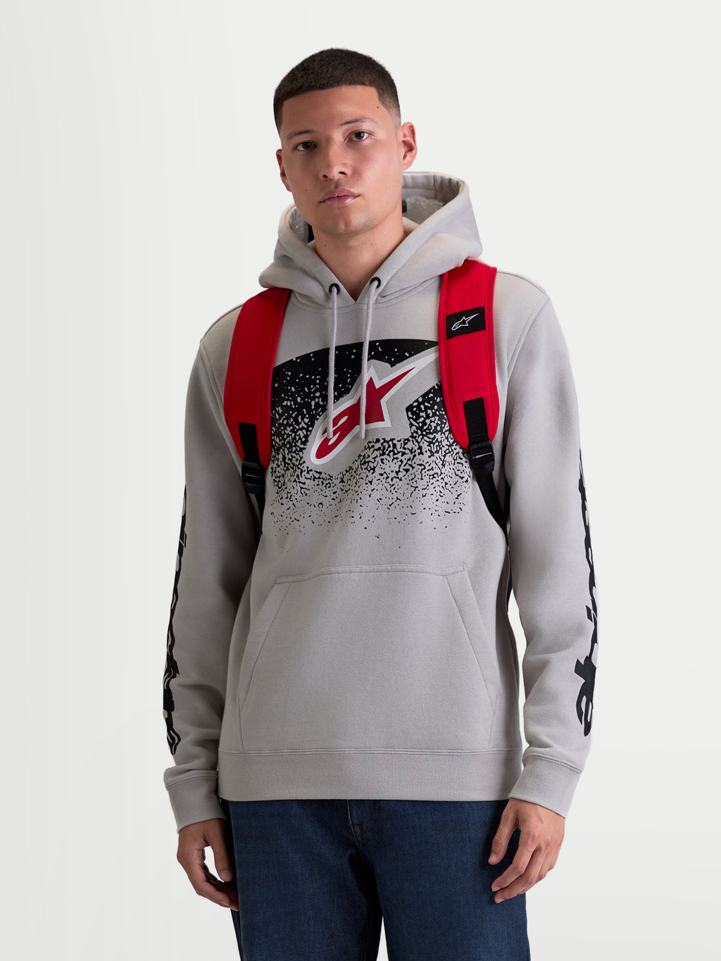 Alpinestars Mochila GFX Boss, mochila urbana de 20L para hombre y mujer, roja y negra, poliéster 600D duradero, vista frontal en modelo con correas de hombro ajustables de malla de aire y logotipo de silicona en relieve