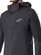 Chaqueta impermeable Alpinestars A-Dura Elite, chaqueta de ciclismo MTB, negra, con membrana impermeable de 3 capas, capucha compatible con casco, bolsillos con cremallera y textura técnica ripstop para el ciclismo de montaña en senderos
