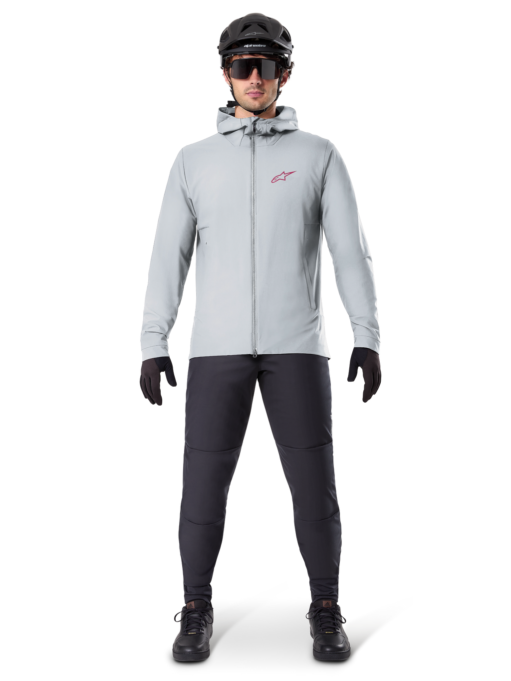 Chaqueta térmica Alpinestars A-Dura, gris titanio, chaqueta de ciclismo usada con pantalones de ciclismo de montaña negros, guantes y casco, con un pequeño logotipo de estrella roja en el pecho y cremallera frontal completa, equipo aislante ligero para ciclismo todoterreno.