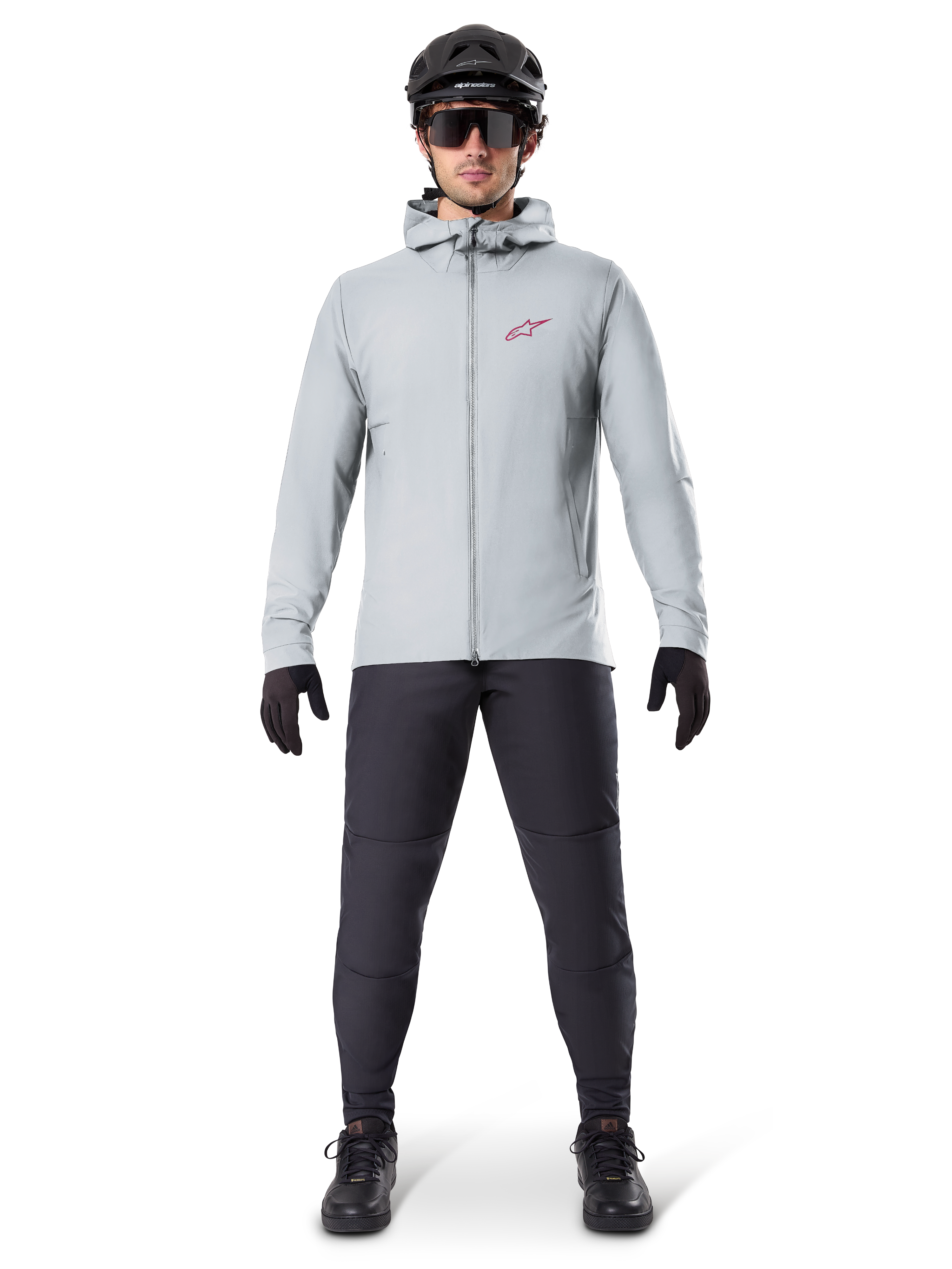 Chaqueta térmica Alpinestars A-Dura, gris titanio, chaqueta de ciclismo usada con pantalones de ciclismo de montaña negros, guantes y casco, con un pequeño logotipo de estrella roja en el pecho y cremallera frontal completa, equipo aislante ligero para ciclismo todoterreno.
