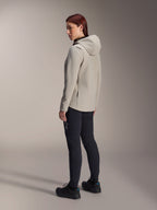 Chaqueta térmica Alpinestars Stella A-Dura en color gris titanio, vista trasera de tres cuartos de una mujer con la chaqueta de ciclismo con capucha y aislamiento y pantalones de MTB negros, toma de estudio que muestra el ajuste regular y el detalle del bolsillo.