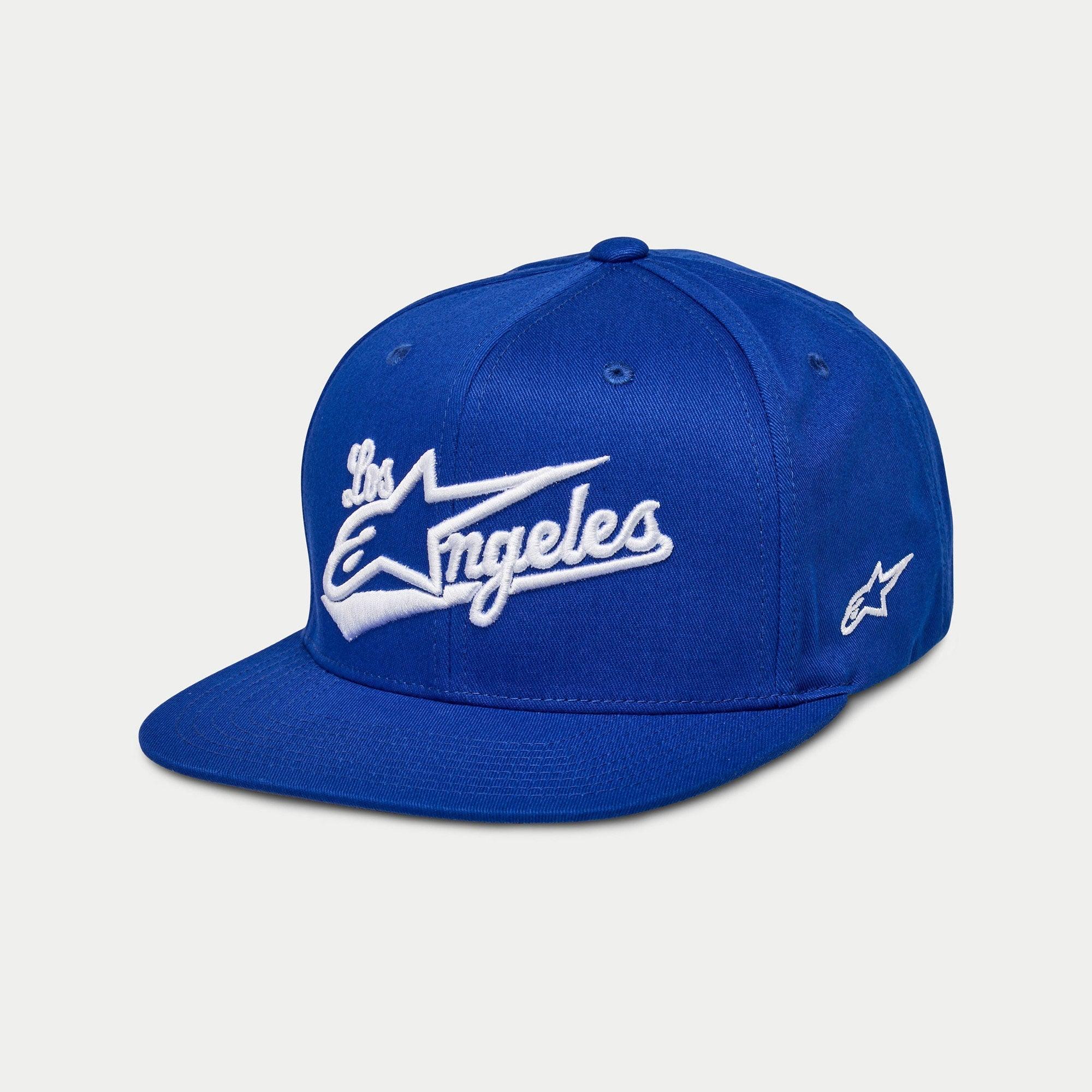 Gorra Alpinestars Los Angeles, gorra snapback de visera plana, azul con bordado 3D de 'Los Angeles' en blanco con fuente atlética, logotipo Ageless en el lateral, corona estructurada, accesorio casual inspirado en el automovilismo