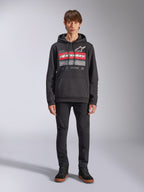 Alpinestars Harken Hoodie, sudadera negra con capucha, gráfico llamativo en el pecho con franjas rojas y el texto 'Racing Ahead', logotipo Astars blanco, bolsillo canguro, capucha con cordón, ropa urbana casual inspirada en el automovilismo