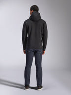 Sudadera con capucha Alpinestars Blaze V3, estilo urbano casual, negro, vista posterior de sudadera de felpa con capucha, combinada con vaqueros denim azul oscuro y zapatos negros, diseño limpio inspirado en el automovilismo