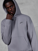 Alpinestars Essentials Ageless Hoodie, Silver, male model wearing the hoodie with the hood up, small black Alpinestars logo on the chest, kangaroo pocket, ribbed cuffs, casual lifestyle streetwear