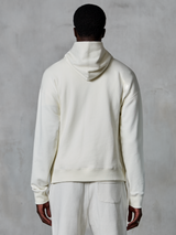 Alpinestars Essentials Ageless Hoodie, sudadera con capucha en color blanco roto, vista trasera en modelo, diseño minimalista y limpio, pantalones casuales a juego, ajuste relajado para comodidad diaria