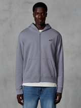 Alpinestars Essentials Ageless Zip Hoodie, color plata, ropa urbana casual usada por un modelo, sudadera de forro polar con cremallera completa, pequeño logo negro de Astars en el pecho, bolsillos de canguro, diseño de ajuste relajado