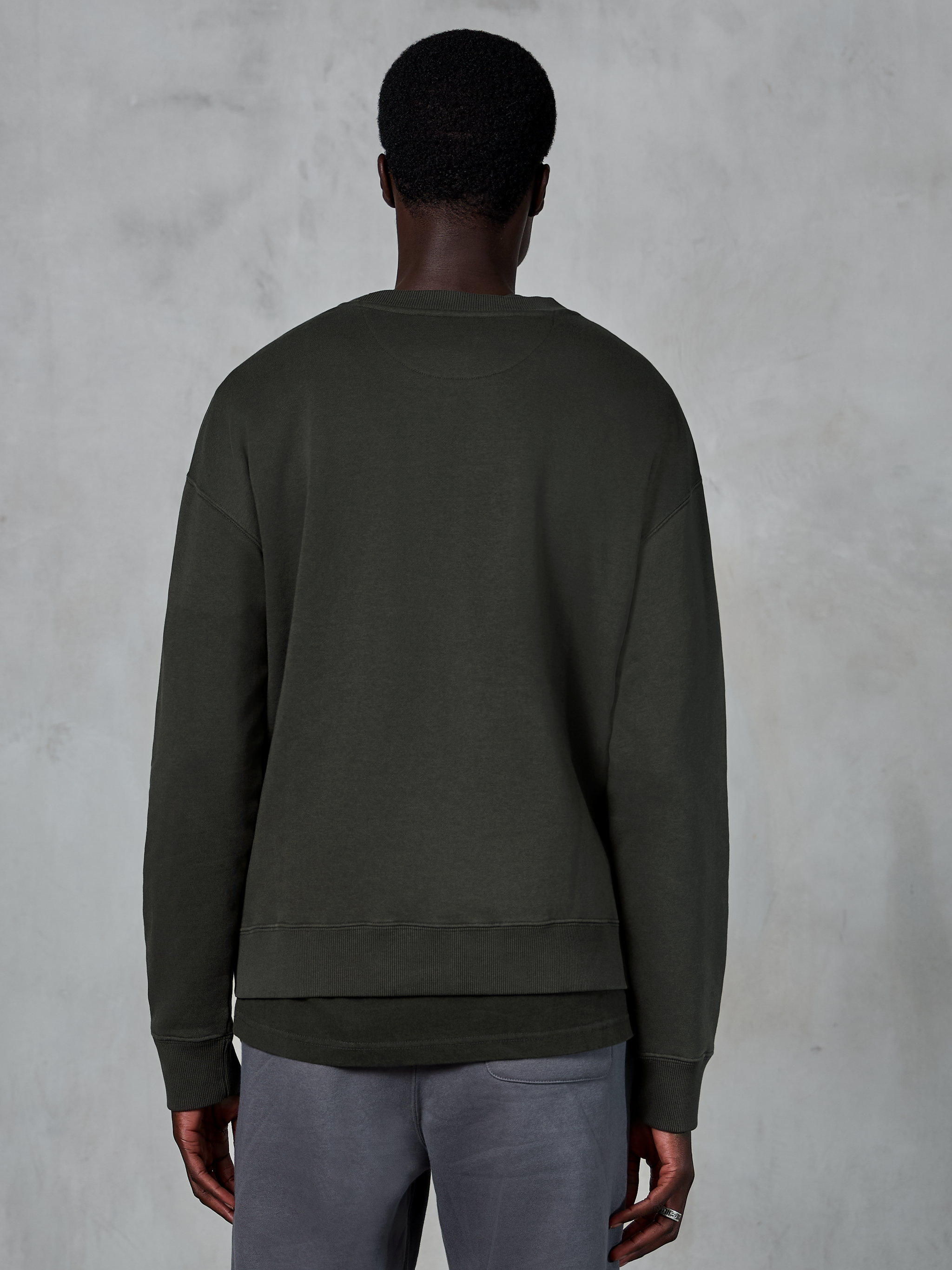 Alpinestars Essentials Ageless Crew, sudadera premium de cuello redondo, negro, vista trasera, ropa de estilo de vida casual con un ajuste relajado, puños y dobladillo acanalados.