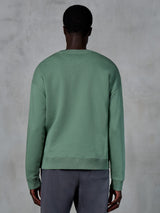 Alpinestars Essentials Ageless Crew, sudadera de cuello redondo, verde cactus, vista posterior en modelo, puños y dobladillo acanalados, forro polar compacto premium, ropa casual de estilo urbano