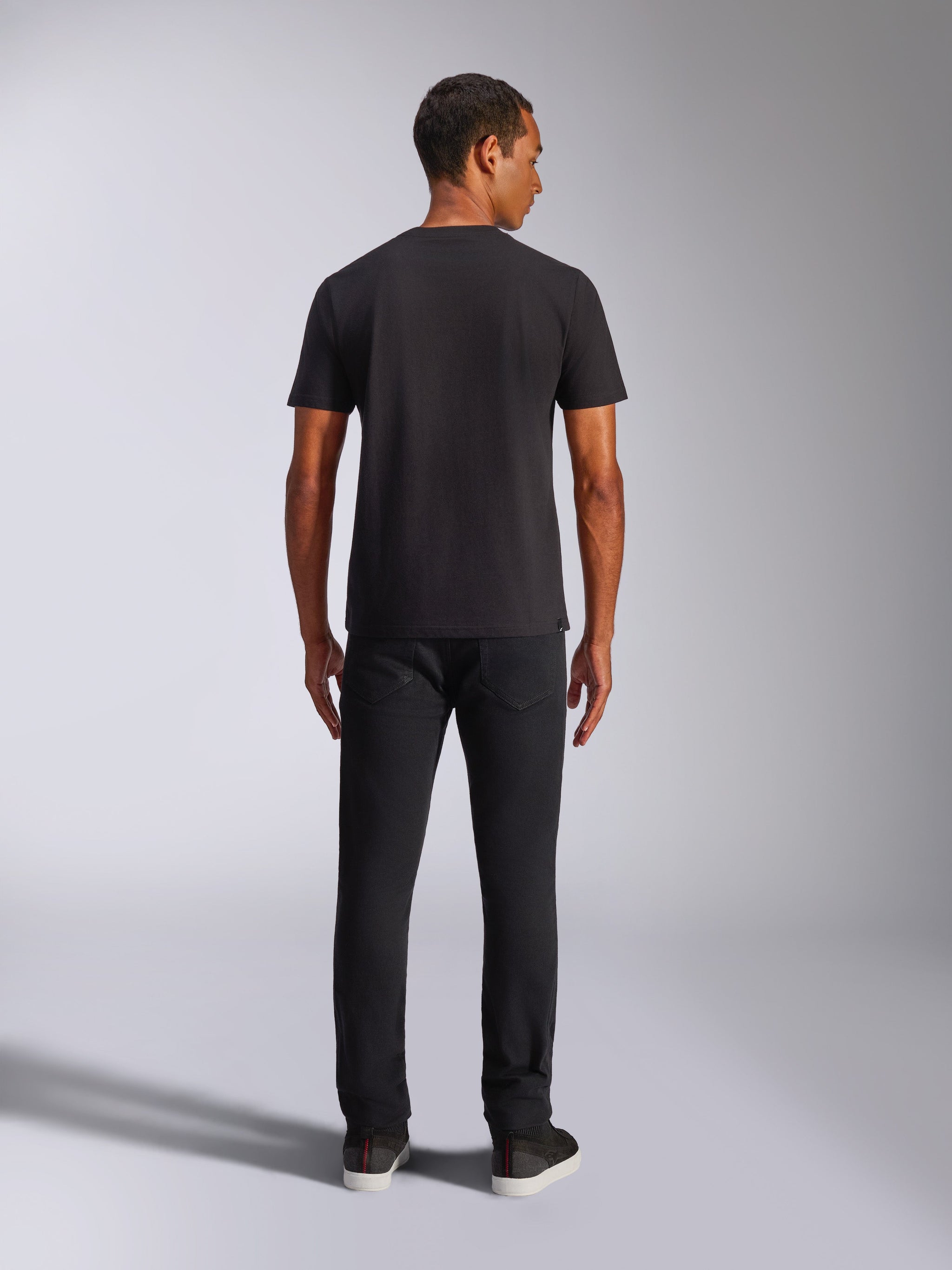 Alpinestars Shaded CSF Tee, camiseta de manga corta, negra, vista trasera en modelo con pantalones negros, ropa urbana casual inspirada en el motorsport