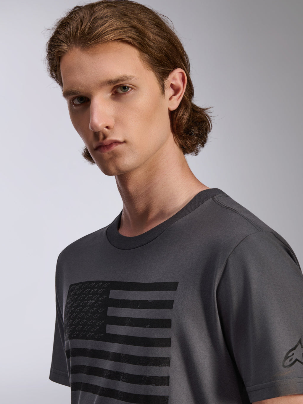Camiseta Alpinestars Waving CSF de manga corta, color carbón, con un gráfico de bandera negra de estilo desgastado con pequeños logos de estrellas, ropa deportiva casual para hombre