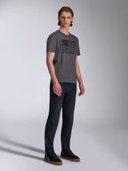 Alpinestars Waving CSF Tee, camiseta de manga corta, gris carbón, gráfico de bandera ondeante negra, usada por un modelo con vaqueros oscuros y zapatillas, ropa urbana casual de estilo motorsport