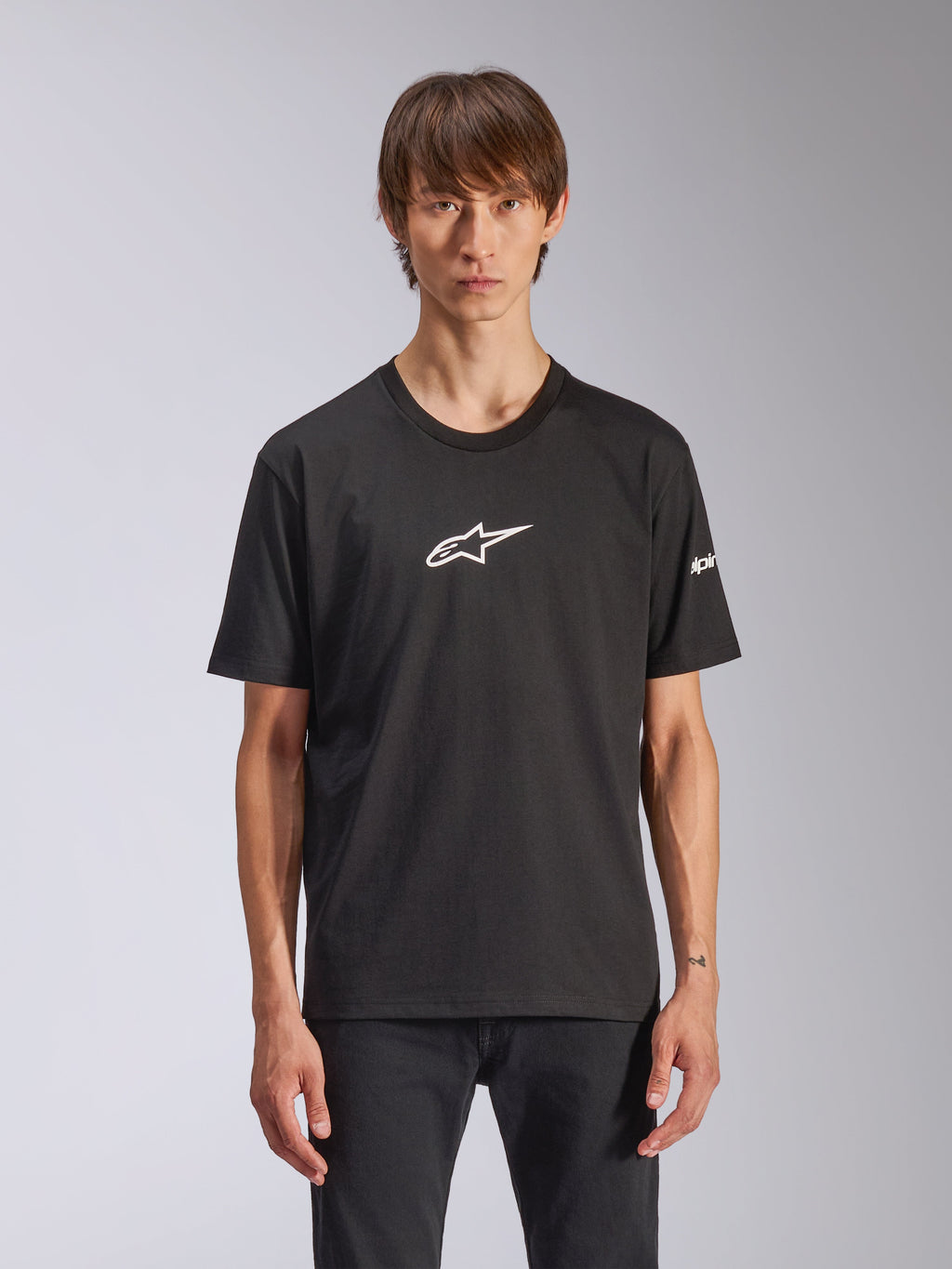 Alpinestars Frontal CSF Tee, camiseta de manga corta, negra, logo blanco de Astars en el pecho, usada por un modelo, ropa casual de automovilismo