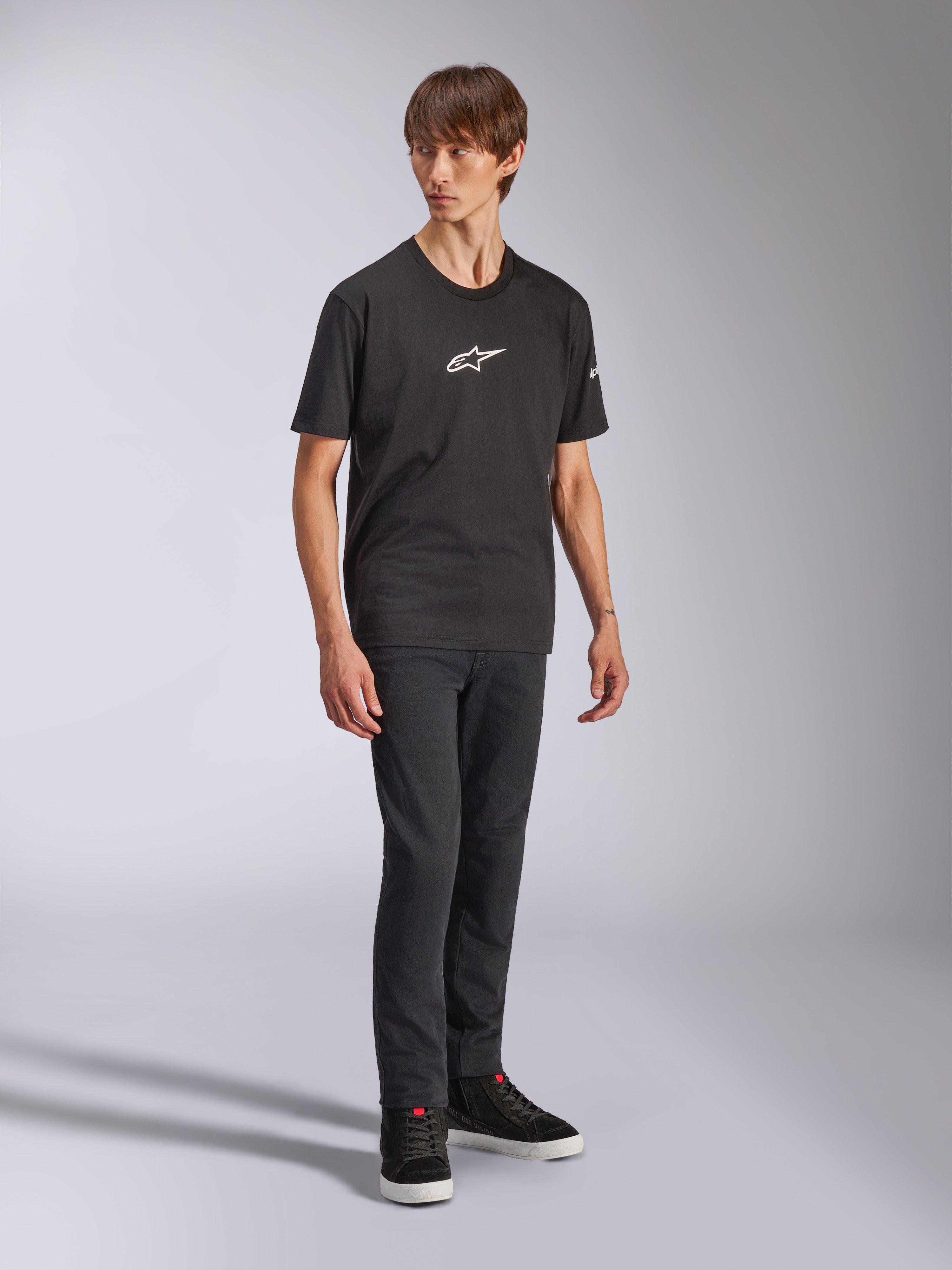 Alpinestars Frontal CSF Tee, camiseta de manga corta, negra, logo Astars blanco en el pecho, usada por un modelo con vaqueros oscuros y zapatillas negras, ropa de calle casual de alto rendimiento