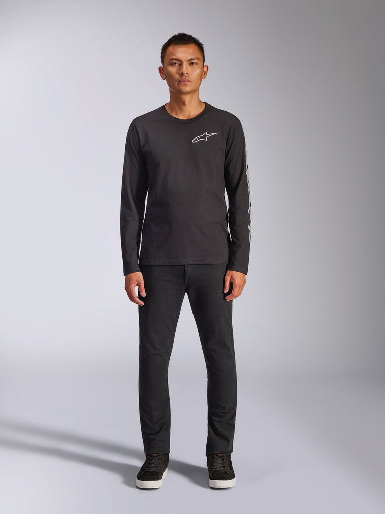 Camiseta Alpinestars Trackside CSF, camiseta de manga larga, negra, logotipo blanco de Alpinestars en el pecho y marca gráfica en la manga, usada con pantalones negros y zapatillas, ropa urbana casual inspirada en el motor