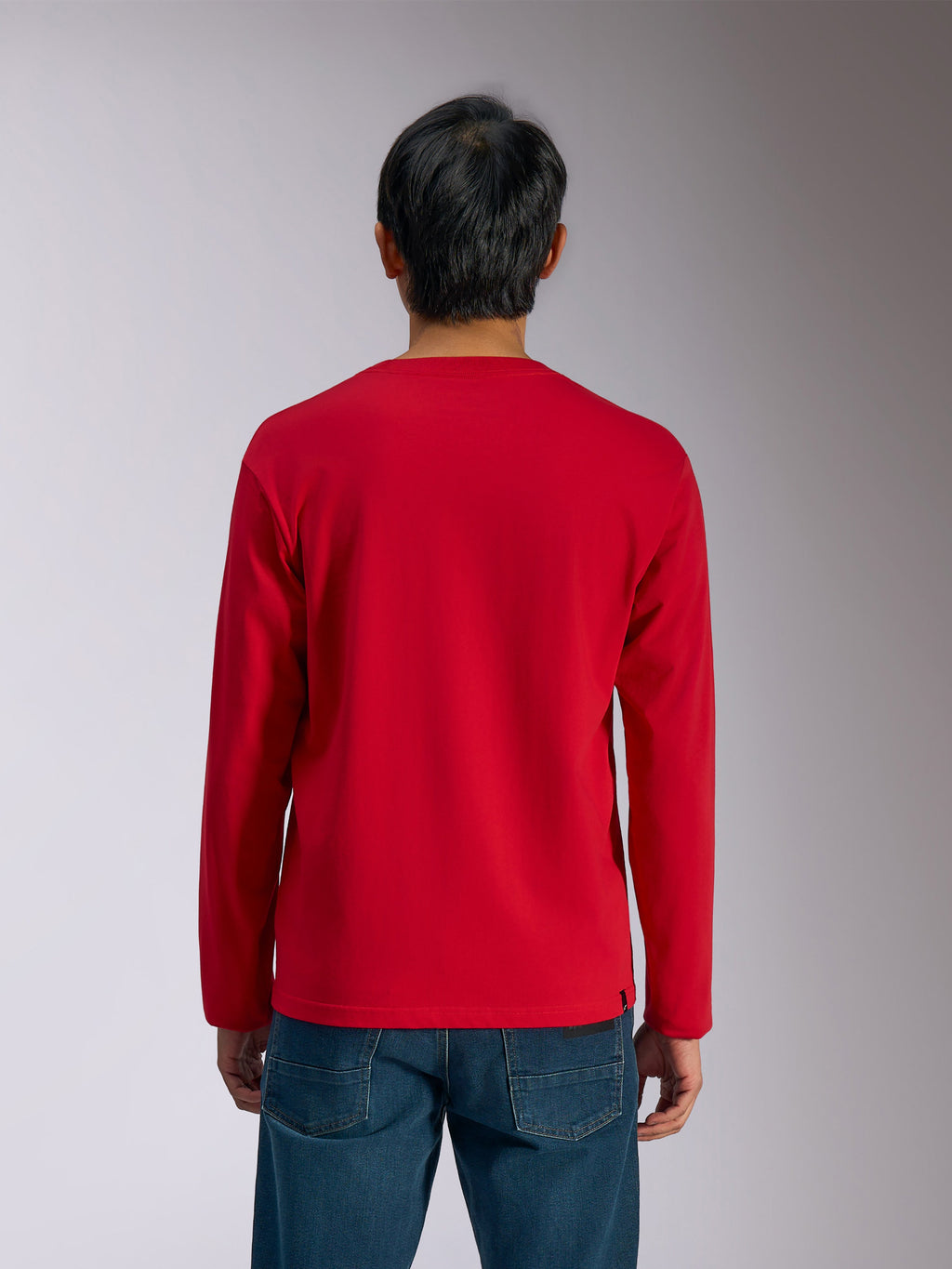 Alpinestars Trackside CSF Tee, camiseta de manga larga, roja, vista trasera, usada por un modelo con vaqueros azules, ropa deportiva casual inspirada en el automovilismo