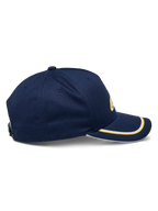 Gorra Alpinestars Ascension Snapback, vista lateral, azul marino con doble ribete sutache en dorado y blanco en la visera curva, corona estructurada, gorra casual de estilo motorsport