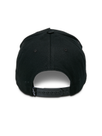 Gorra Alpinestars Specific Snapback, negra, vista trasera con un cierre de presión de plástico ajustable y un pequeño logotipo Astars blanco en la etiqueta trasera, corona estructurada, accesorio de cabeza casual de estilo motorsport