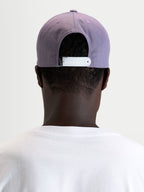 Gorra Ageless Snapback Alpinestars, gorra sportswear, morada con cierre ajustable blanco, vista trasera en modelo