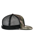 Gorra Trucker Plana Flag de Alpinestars, color verde camuflaje y negro, perfil lateral con visera plana de camuflaje, frente estructurado y malla trasera negra transpirable, cierre a presión, accesorio casual de motorsport