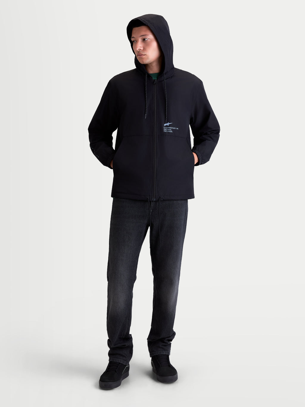 Alpinestars Speeder Resolve, chaqueta cortavientos con capucha para hombre, negra, 100% poliéster con forro de malla y logotipos en el pecho, vista de modelo con estilo casual urbano