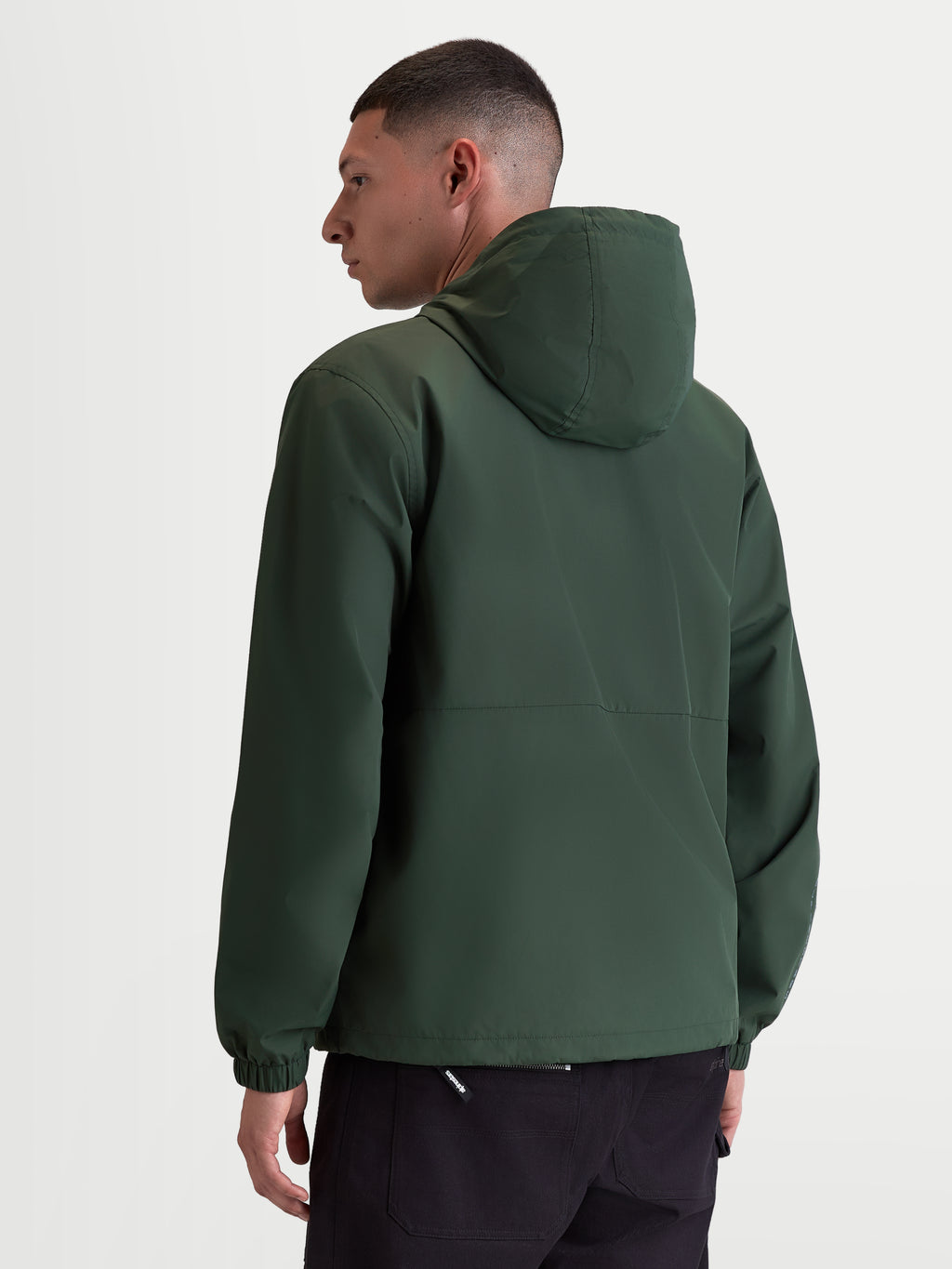 Alpinestars Chaqueta Cortavientos Speeder Resolve, cortavientos ligero para hombre de uso urbano, verde pino, poliéster con forro de malla, vista trasera en modelo mostrando el diseño limpio de la espalda, la capucha y los puños elásticos