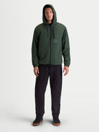 Alpinestars chaqueta cortavientos Speeder Resolve, chaqueta con capucha para hombre, verde pino, ligera y transpirable con forro de malla, logotipo en el pecho, ropa deportiva de estilo casual, vista frontal en modelo