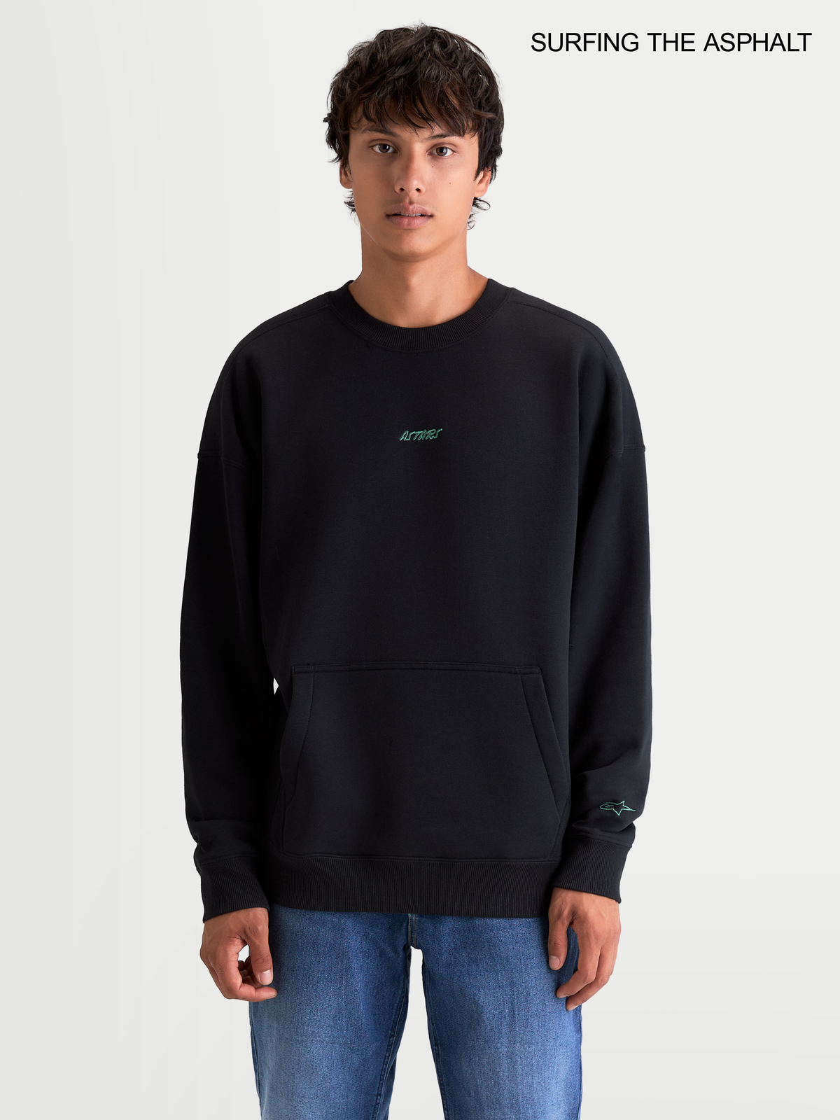 Alpinestars Guise Oversized Crew, jersey de felpa para hombre en negro, con corte holgado, cuello redondo, bolsillo canguro frontal y logotipo bordado, vista frontal en modelo