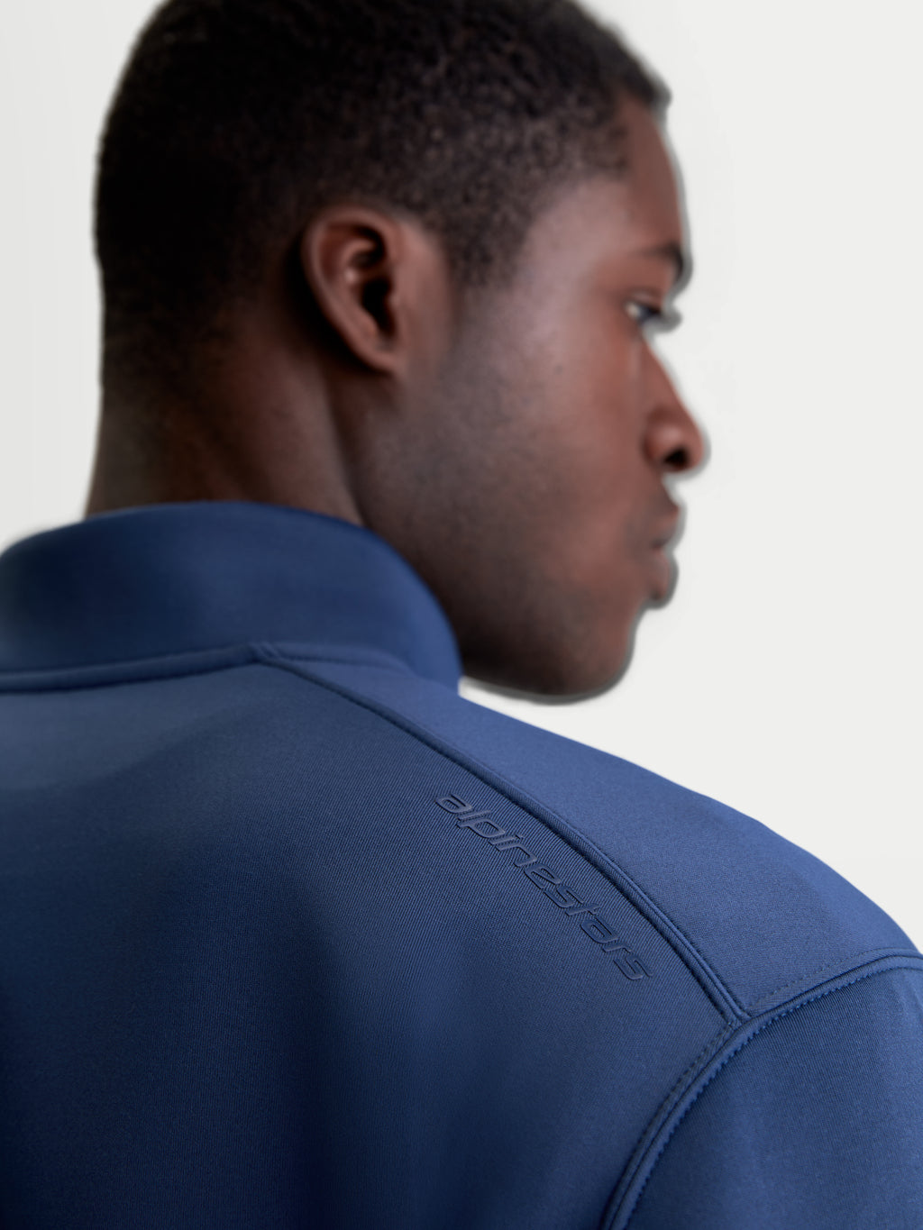 Alpinestars Sudadera Apera Half-Zip, sudadera de sportswear en azul acero, vista de primer plano de la espalda sobre modelo que muestra el logotipo Alpinestars HD tonal en el hombro y el tejido de forro polar premium de mezcla triple