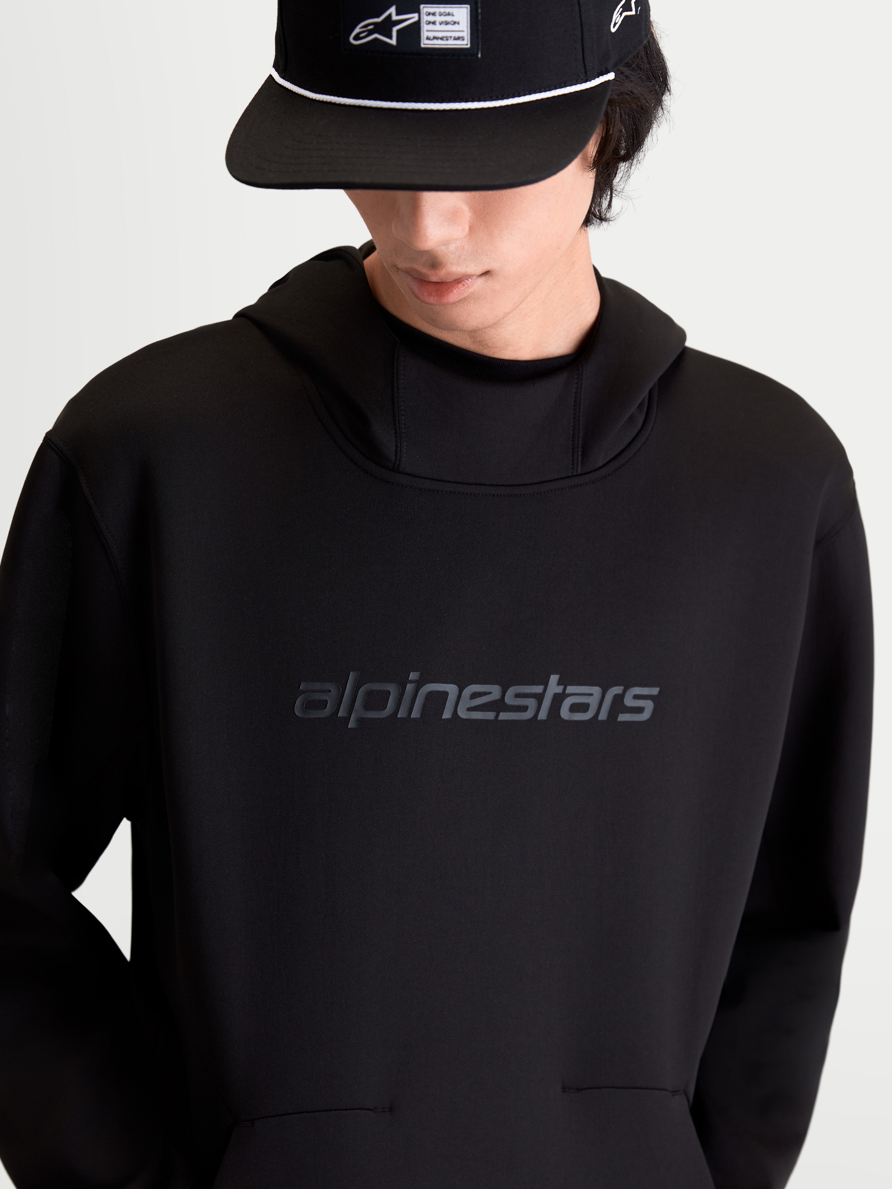 Alpinestars sudadera con capucha Datrix, pulóver de sportswear casual, negra, forro polar de doble cara, logotipo Alpinestars HD tonal en el pecho, capucha con forro de malla y bolsillo con detalle de pliegue, vista frontal en modelo.