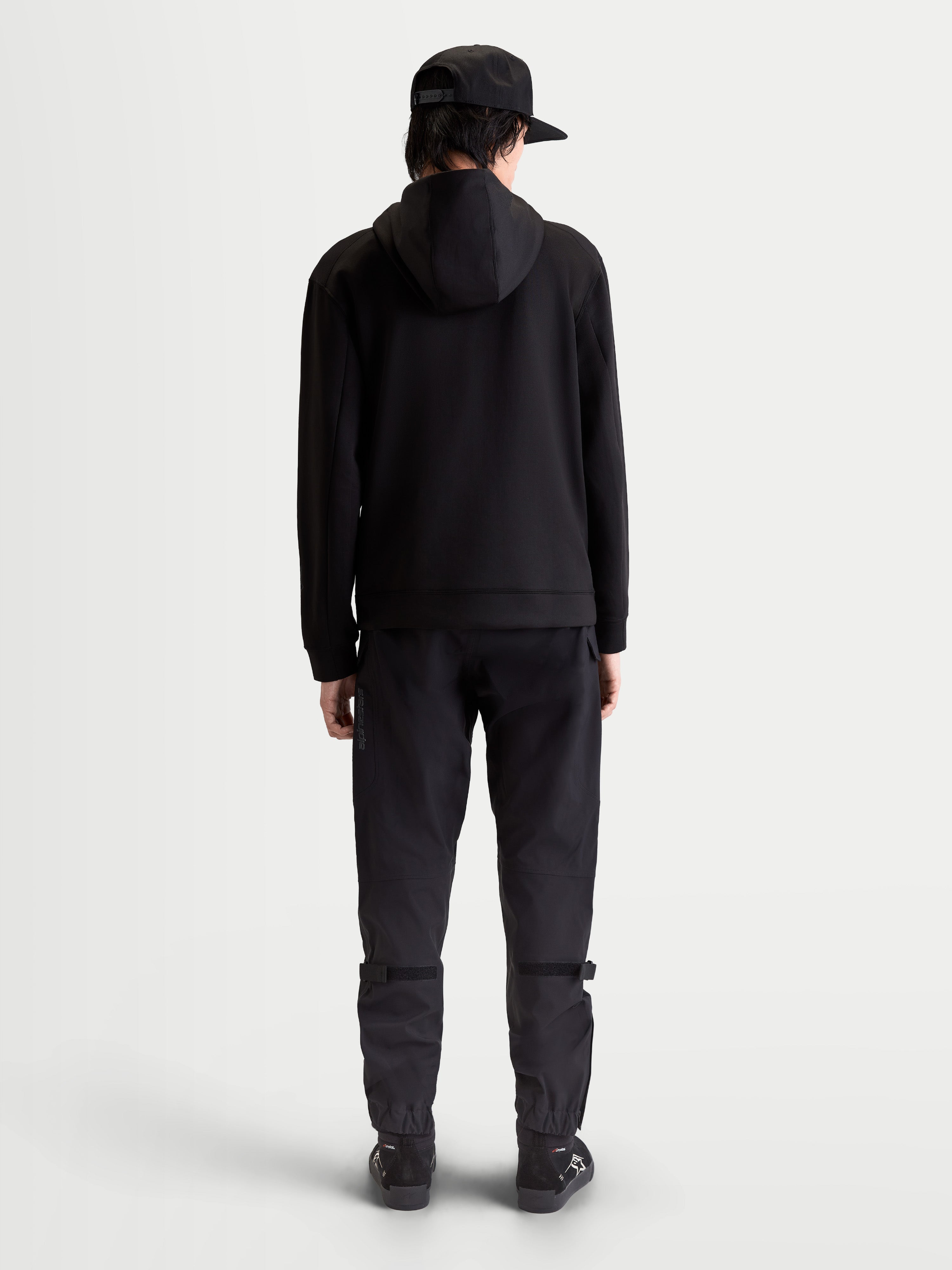 Alpinestars sudadera con capucha Datrix, pulóver de ropa deportiva premium, negro, vista trasera en modelo, forro polar de doble cara en mezcla triple con capucha forrada de malla y estilo de inspiración motorsport