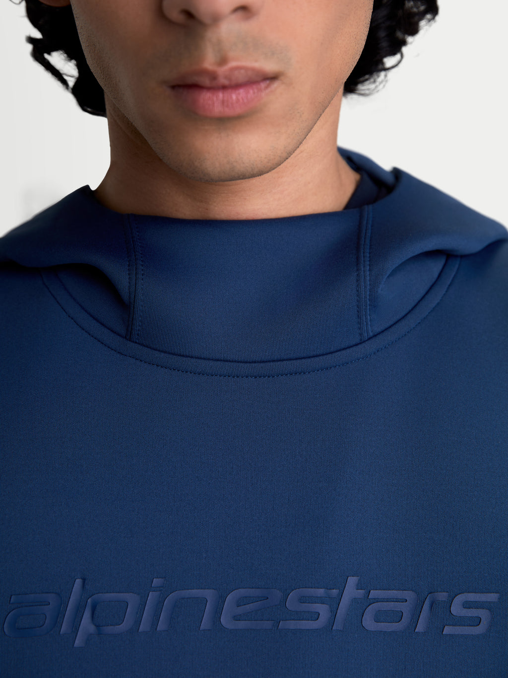 Alpinestars Datrix, sudadera con capucha para hombre y mujer, azul acero, primer plano del logotipo Alpinestars HD tonal en el pecho y detalle del cuello con forro de malla, confeccionada en forro polar de doble cara premium, ropa deportiva de inspiración motorsport.