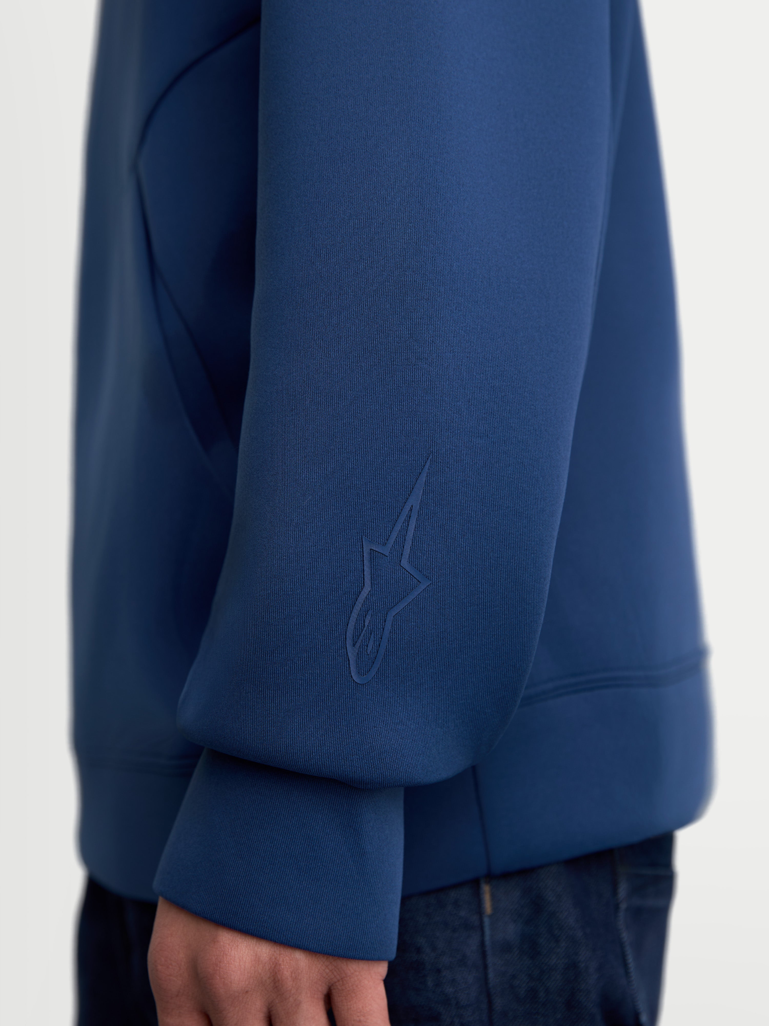 Alpinestars Sudadera con capucha Datrix, ropa deportiva de estilo casual, azul, primer plano de la manga con detalle de logotipo HD tonal, confeccionada en tejido de forro polar de doble cara