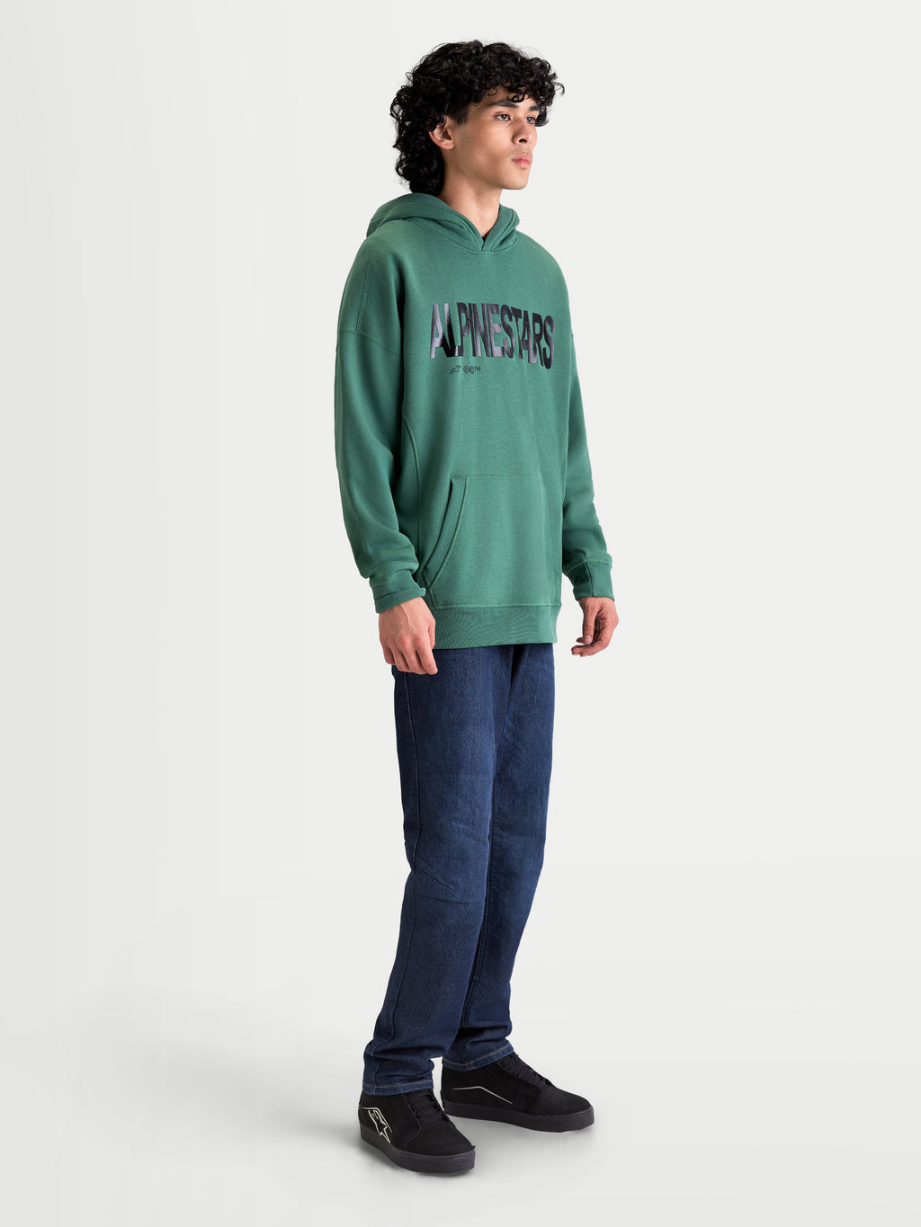 Alpinestars sudadera con capucha Shaw Oversized, ropa deportiva de hombre, verde, con logotipo texturizado de Alpinestars, bolsillo canguro y ajuste oversized relajado en forro polar de algodón y poliéster reciclado, mostrada en modelo