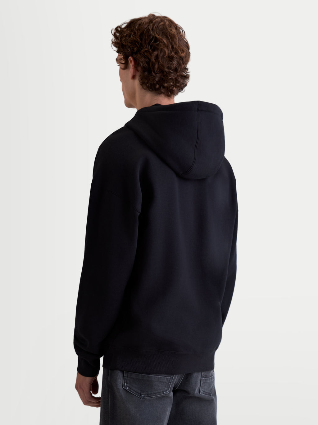 Alpinestars Prelude Oversized, sudadera con capucha de forro polar unisex, negra, vista trasera que muestra la silueta relajada, capucha forrada y puños y dobladillo de canalé para un acabado limpio.