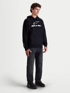 Sudadera con capucha Prelude Oversized de Alpinestars, sudadera de forro polar para hombre, negra con logotipo en relieve blanco, ajuste oversized relajado y bolsillo canguro, ropa deportiva casual mostrada en un modelo.